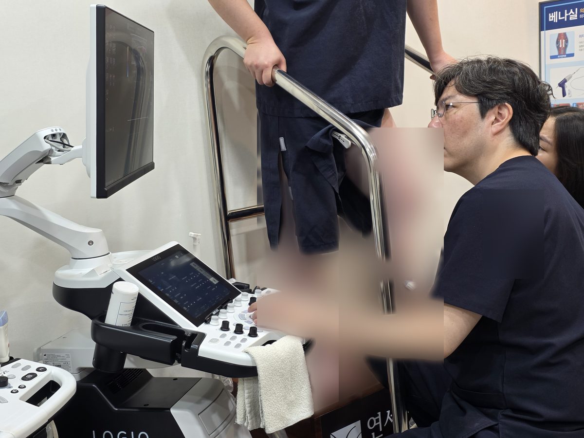 의료진이 초음파 장비로 환자의 다리를 검사하는 모습.