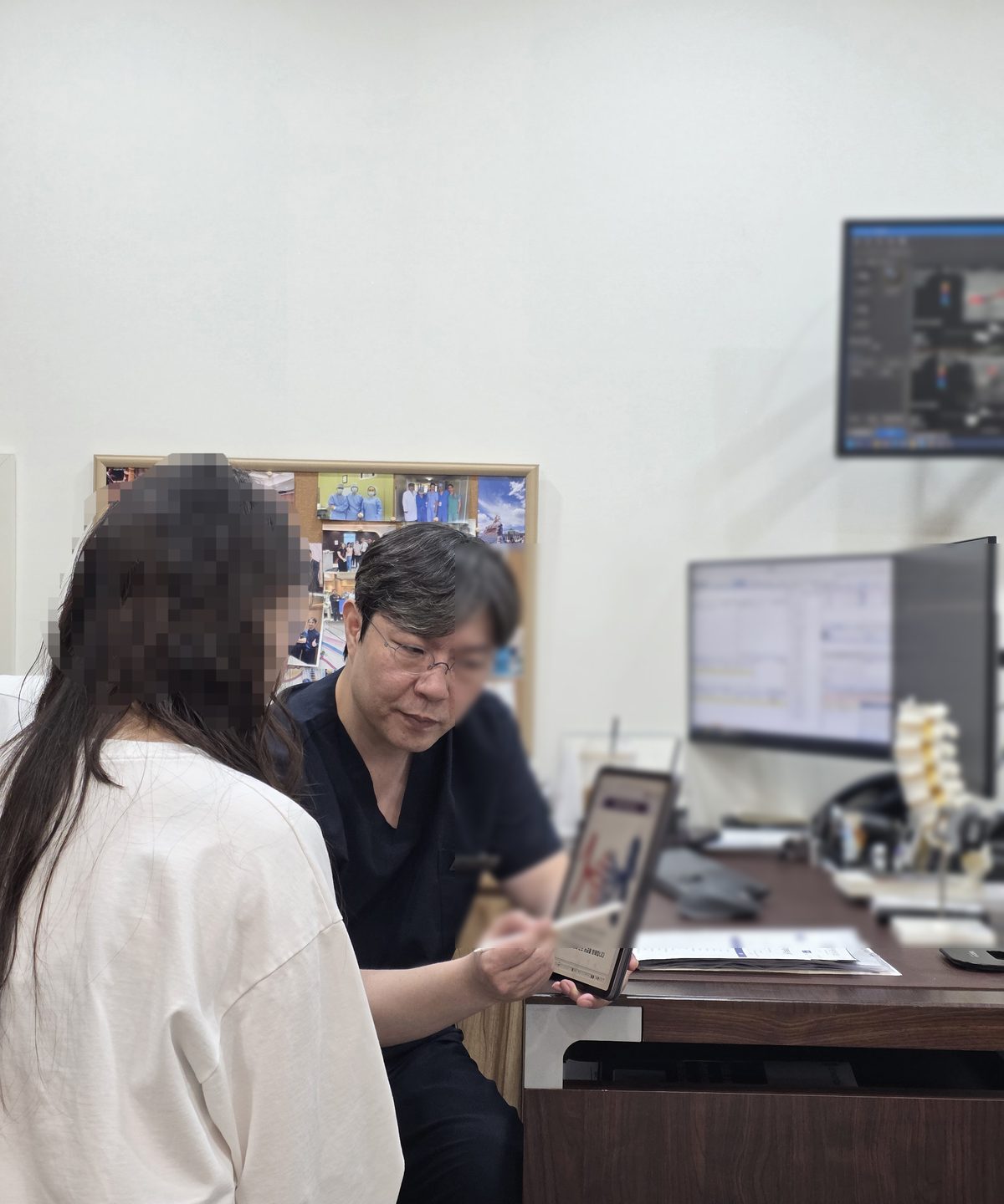 대표원장이 진료실에서 태블릿의 정맥 그림을 보여 주며 환자와 상담하는 모습