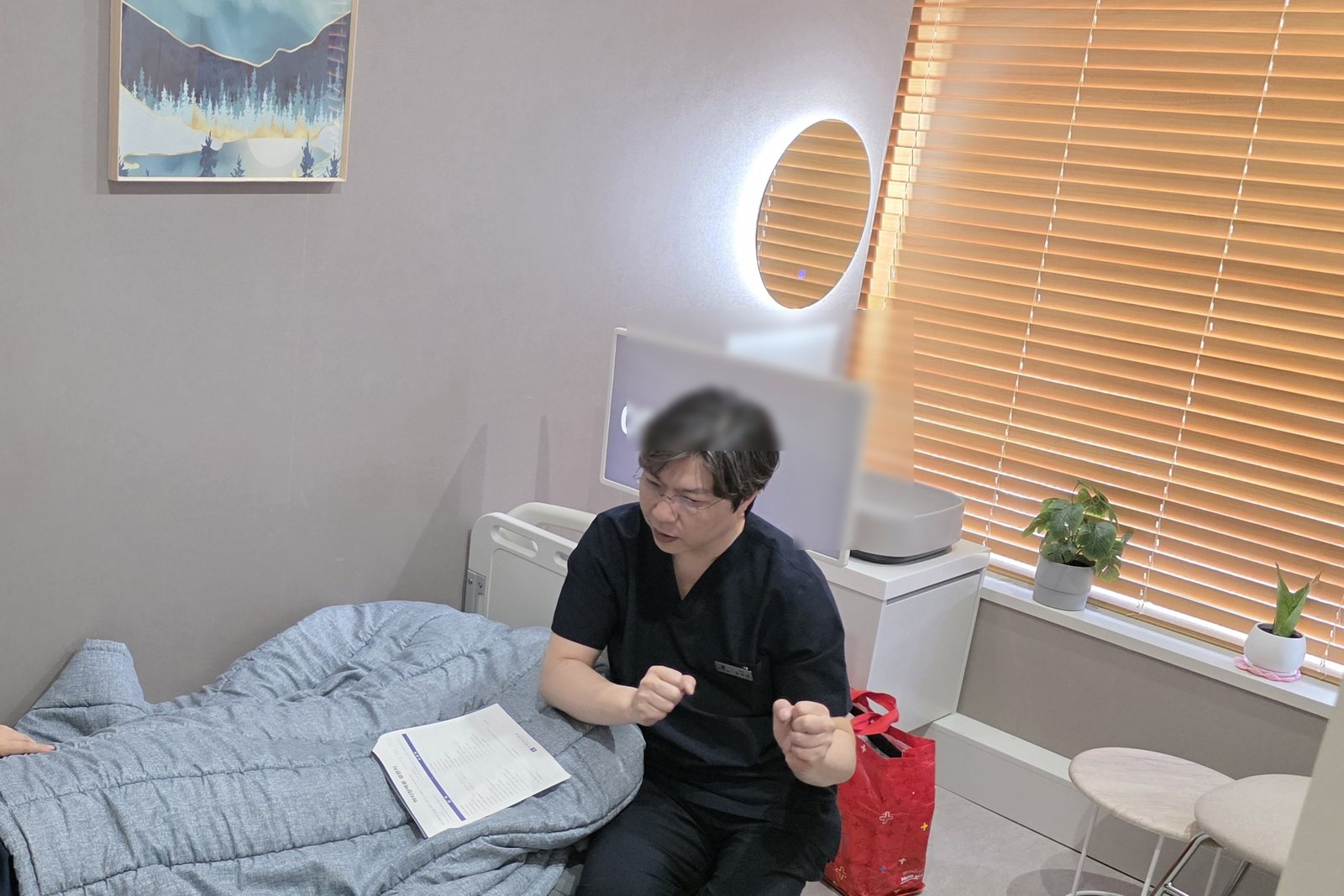 의료진이 진료실에서 침대에 누운 환자와 상담하는 장면.